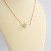 Short dainty necklace with a Pearl in gold tone