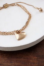 Drawstring golden chain bracelet with a heart charm