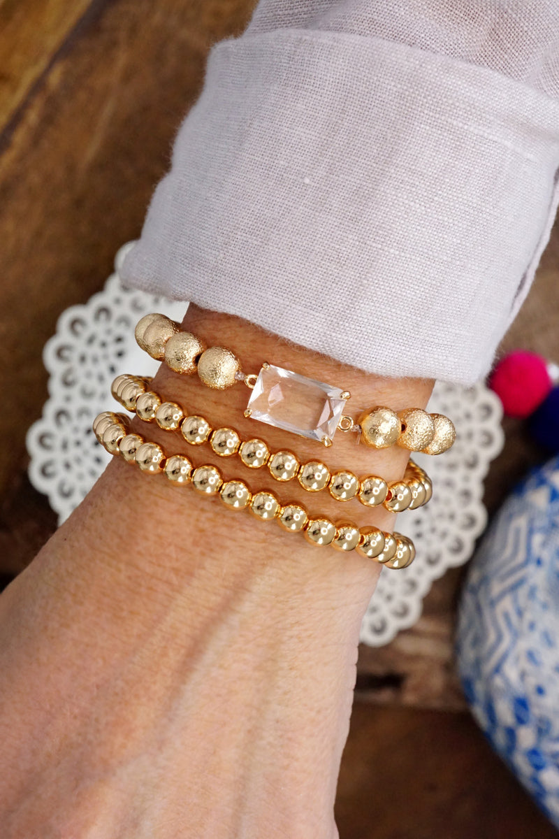 Gold tone multi size ball beaded bracelet stack with a Crystal