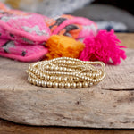 Worn Gold tone multi size beaded bracelet stack of 6 bracelets