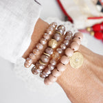 Beaded bracelets set in Blush Pink with a coin charm